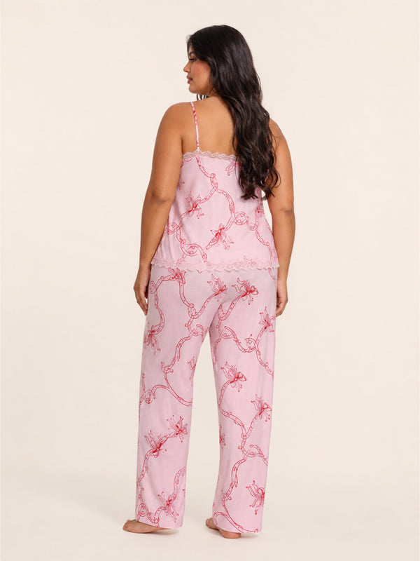 Woman wearing a pink pajama set with a subtle pattern on a beige background
